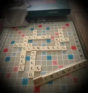 A scrabble board with lots of words relating to dismissal on it to illustrate the power of words.