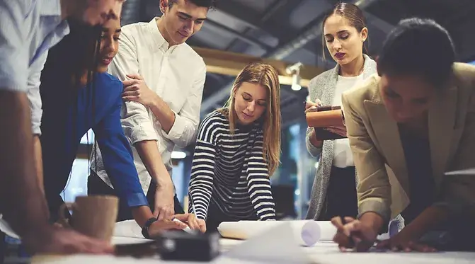 A group of people working together on a project at a table.