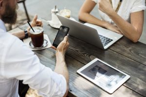 Two people talking over a laptop.